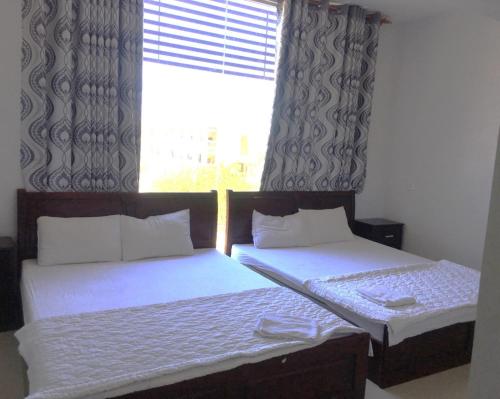 潘郎Nam Dương 2 Hotel的带窗户的客房内设有两张单人床。