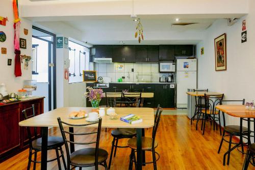 库斯科Net House Cusco的厨房以及带木桌和椅子的用餐室。