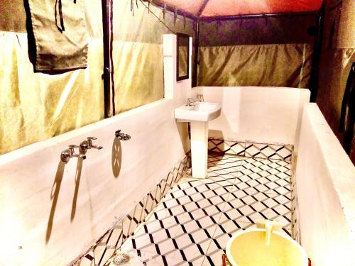 奈尼塔尔The Janvi Camping Resort的浴室配有水槽、浴缸和水槽