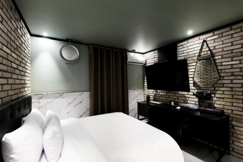 首尔Stay 25 Hotel的一间卧室配有一张床和一台平面电视