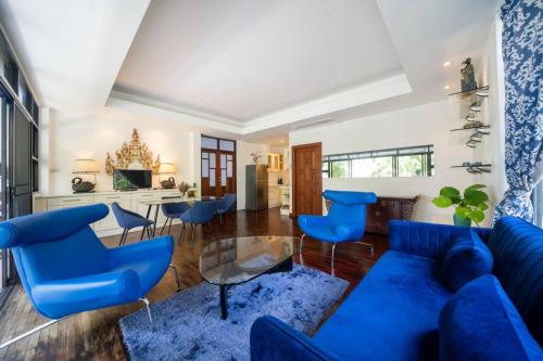 卡马拉海滩Kamala Beach Estate Resort - SHA Extra Plus的客厅配有蓝色的沙发和椅子