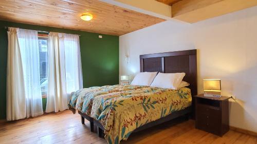 皮奇勒姆Cabañas Punta de Lobos的一间卧室设有一张床和绿色的墙壁