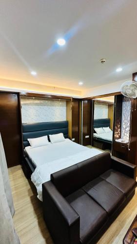 勒克瑙Star Comfort Inn的一间卧室配有一张大床和一张沙发