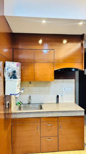 勒克瑙Star Comfort Inn的一个带木制橱柜和水槽的厨房
