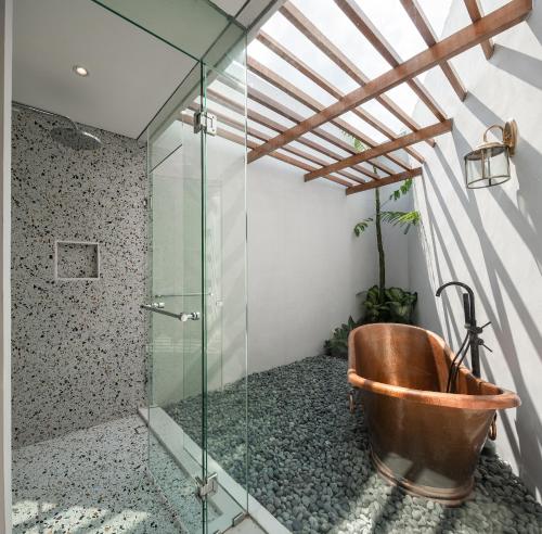 梭罗Gria Kerten的一间带铜浴缸和玻璃淋浴的浴室