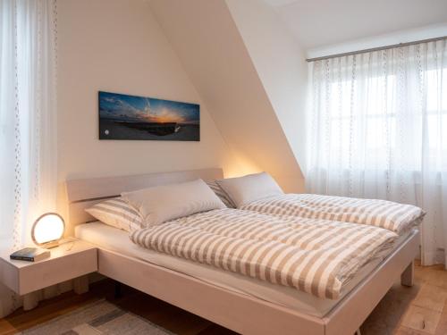 斯匹科罗格Dünenkieker的一间卧室配有带条纹被子的床