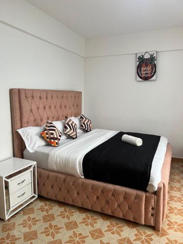 纳库鲁Silva-Mindvalley的一张带皮革床头板和枕头的床