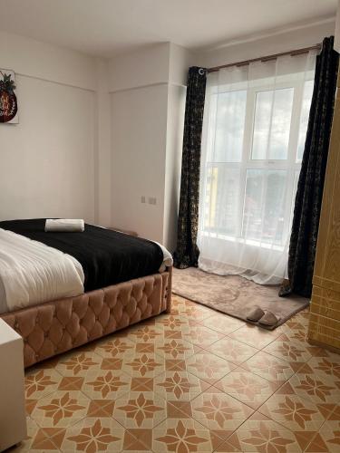纳库鲁Silva-Mindvalley的一间卧室设有一张床和一个大窗户