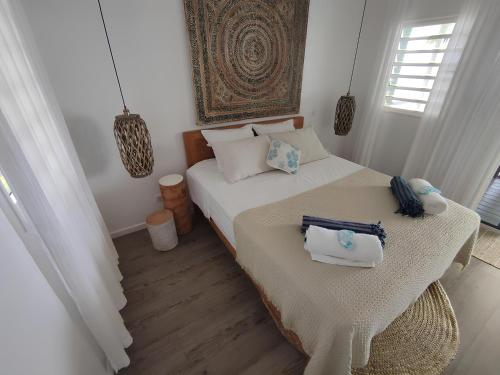 PatioLuxury Waterfront Bungalow + Car的一间卧室配有一张床,上面有两条毛巾