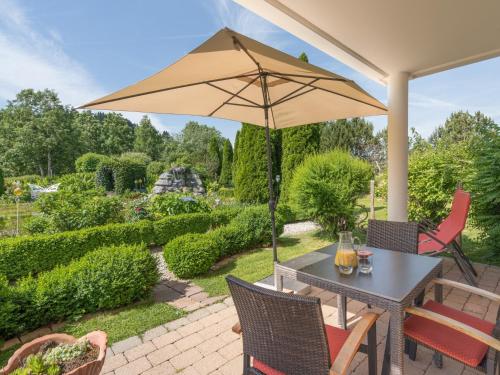 韦尔塔赫Wellnesshof Blenk的一个带桌子和遮阳伞的庭院