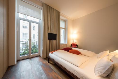 维也纳霍尔曼贝勒塔格设计精品酒店的一间卧室设有一张床和一个大窗户
