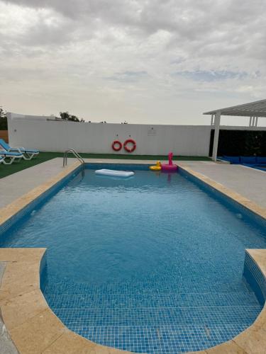 乌姆盖万Falaj Hub Retreat的一个带水滑梯的游泳池和一个游泳池