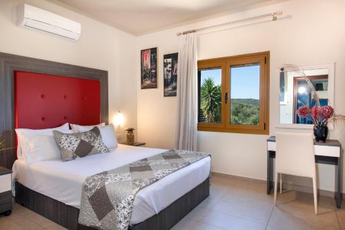 马莱迈Villa Lady Dafni with private heated pool的一间卧室配有一张床、一张书桌和一个窗户。