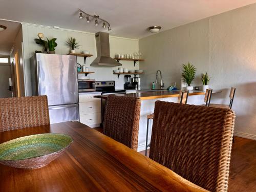 帕依亚North Shore of Maui - 2bd-2bath的厨房配有带椅子的木桌和厨房台面
