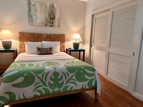 帕依亚North Shore of Maui - 2bd-2bath的一间卧室配有一张带绿色和白色床单的床。