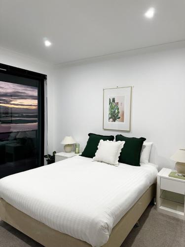 史密斯顿纯趣公寓的白色的卧室设有一张大床和一个窗户