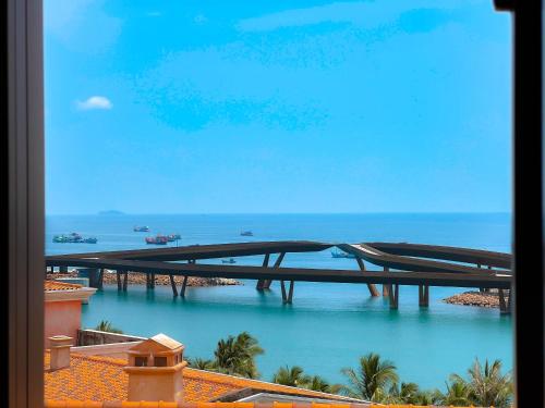 富国Sunset Hotel Phu Quoc - welcome to a mixing world of friends的一座桥,在海边的水域上