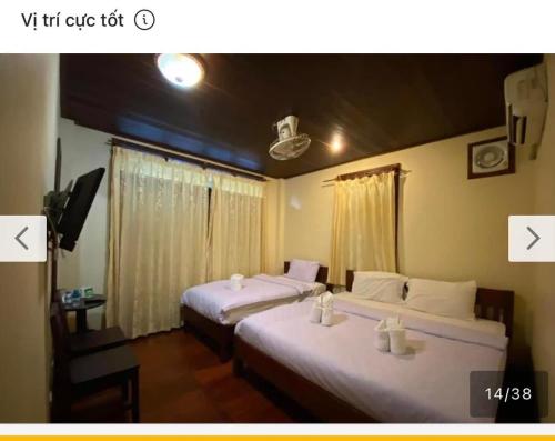 琅勃拉邦Tingkham Guesthouse的带2扇窗户的客房内的2张床