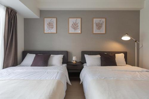 大阪b&道顿堀店的卧室内两张并排的床