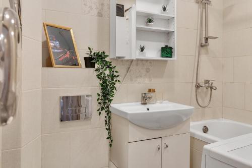 维尔纽斯Tower View Apartment的白色的浴室设有水槽和镜子