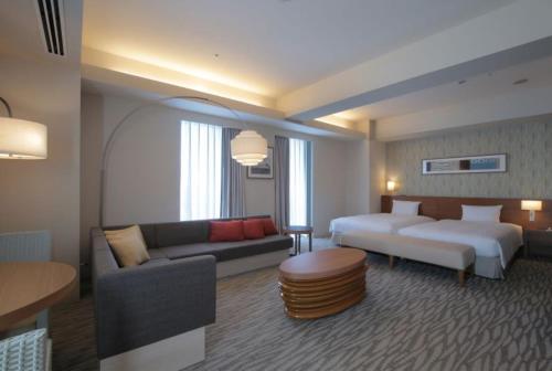 相模原市相模大野小田急世纪饭店的酒店客房,配有床和沙发