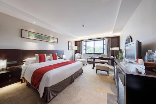 苏州苏州南园宾馆的酒店客房设有一张大床和一张书桌。