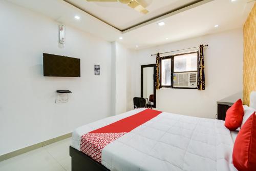 BārmerOYO Hotel Amber Palace的卧室配有一张床,墙上配有电视。