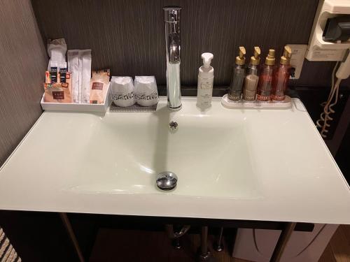 SayamaX Hotel - Adult Only-的浴室内的一个白色水槽,里面装有瓶子