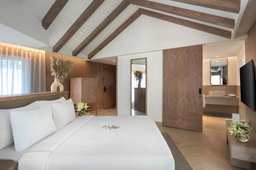加尔加ZANA - A Luxury Escape, Dhikuli, Jim Corbett的卧室配有一张白色大床和电视。