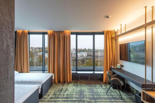 维尔纽斯全景酒店的酒店客房设有一张床和一个大窗户