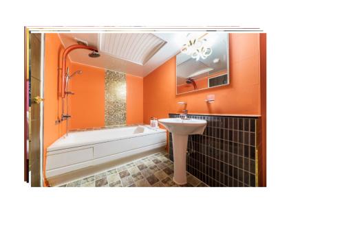 仁川市S1 Hotel的橙色的浴室设有水槽和浴缸。