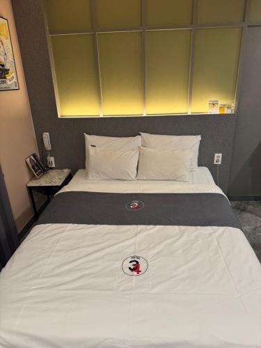 仁川市Seoknam 3&4 Hotel的一张大白色的床,上面有红色按钮