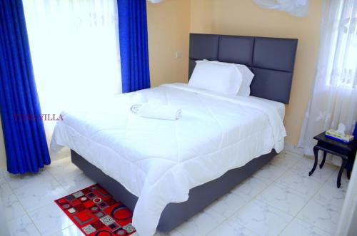 基苏木Yuks Villa的卧室配有一张带蓝色窗帘的大型白色床