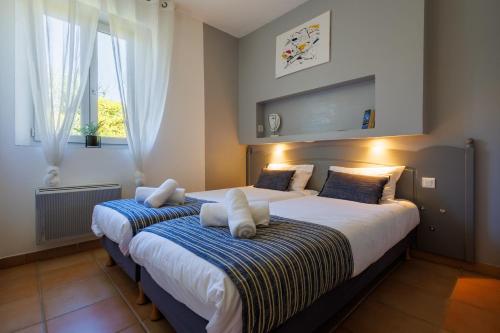 戈尔德Lou Karo - Piscine partagée - Parking privé的卧室设有两张床,带两个窗户
