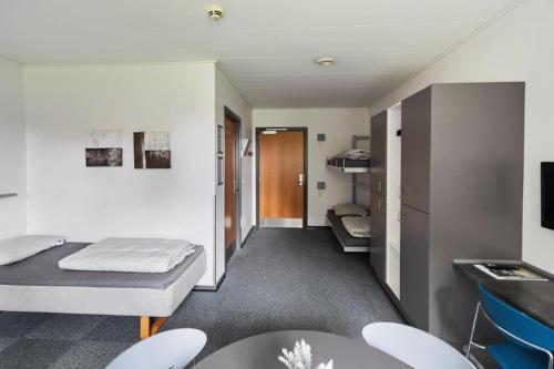埃斯比约埃斯比约大宿舍酒店的配有一张床和一张桌子及椅子的房间