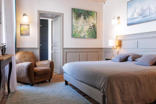 圣马丹德雷La Martinoise Patio的一间卧室配有一张大床和一把椅子