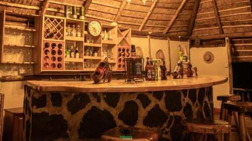 KatokeEmbogo Safari Lodges的一间酒吧,在房间内配有木台