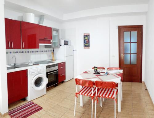 圣伊西德罗Appartamento Mochiri - San Isidro的厨房配有红色橱柜和桌椅