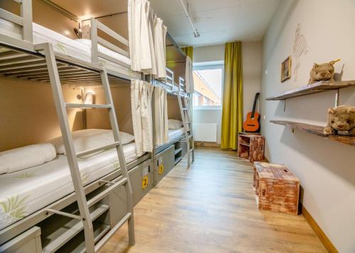 慕尼黑Wombat's City Hostel Munich Werksviertel的一间设有三张双层床和吉他的房间