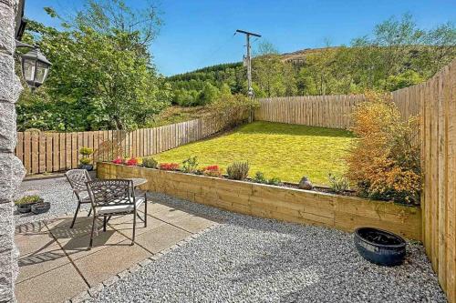 格伦科Outlander Glencoe at Creag an-t Sionnaich的一个带椅子的庭院和一个带围栏的花园