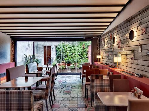 约阿尼纳Z Inn Ioannina的餐厅设有桌椅和大窗户。