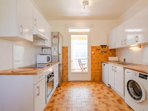 圣艾格夫Holiday Home Le Balzac by Interhome的厨房配有白色橱柜和瓷砖地板。