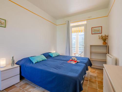 圣艾格夫Holiday Home Le Balzac by Interhome的一间卧室设有蓝色的床和窗户。