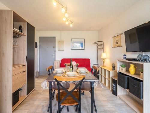 朋泰雷克Apartment Les Balcons de l'Atlantique-12 by Interhome的一间带桌子和红色沙发的用餐室