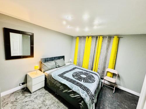 斯托桥4-Bed Full House Stourbridge Birmingham的一间卧室配有床、镜子和黄色窗帘