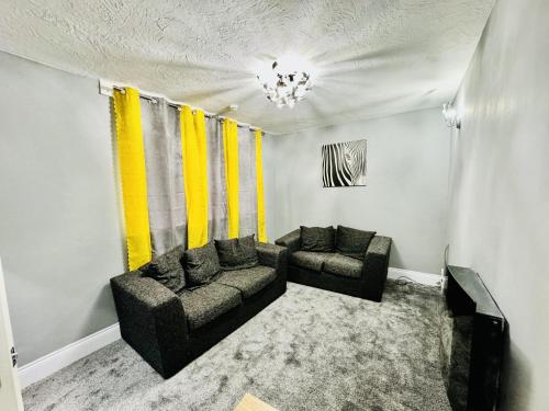 斯托桥4-Bed Full House Stourbridge Birmingham的客厅配有两张沙发和黄色窗帘