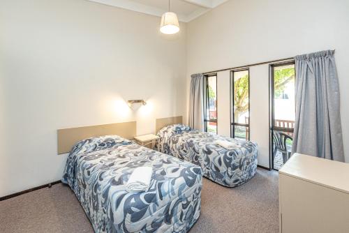 旺格努伊河滨汽车旅馆的酒店客房设有两张床和窗户。