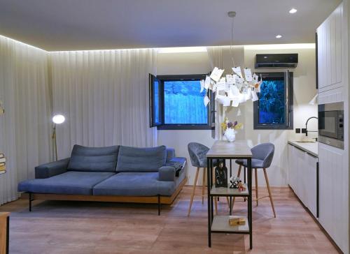 雅典P Faliro Riviera Suite的客厅配有蓝色的沙发和桌子
