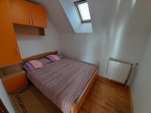 兹拉蒂博尔Apartmani Nova Zova的一间小卧室,配有一张带粉红色枕头的床