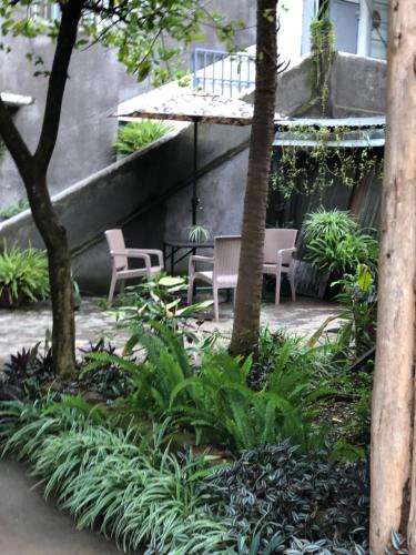 Mbalethe APARTMENT house的花园设有椅子和树木及植物